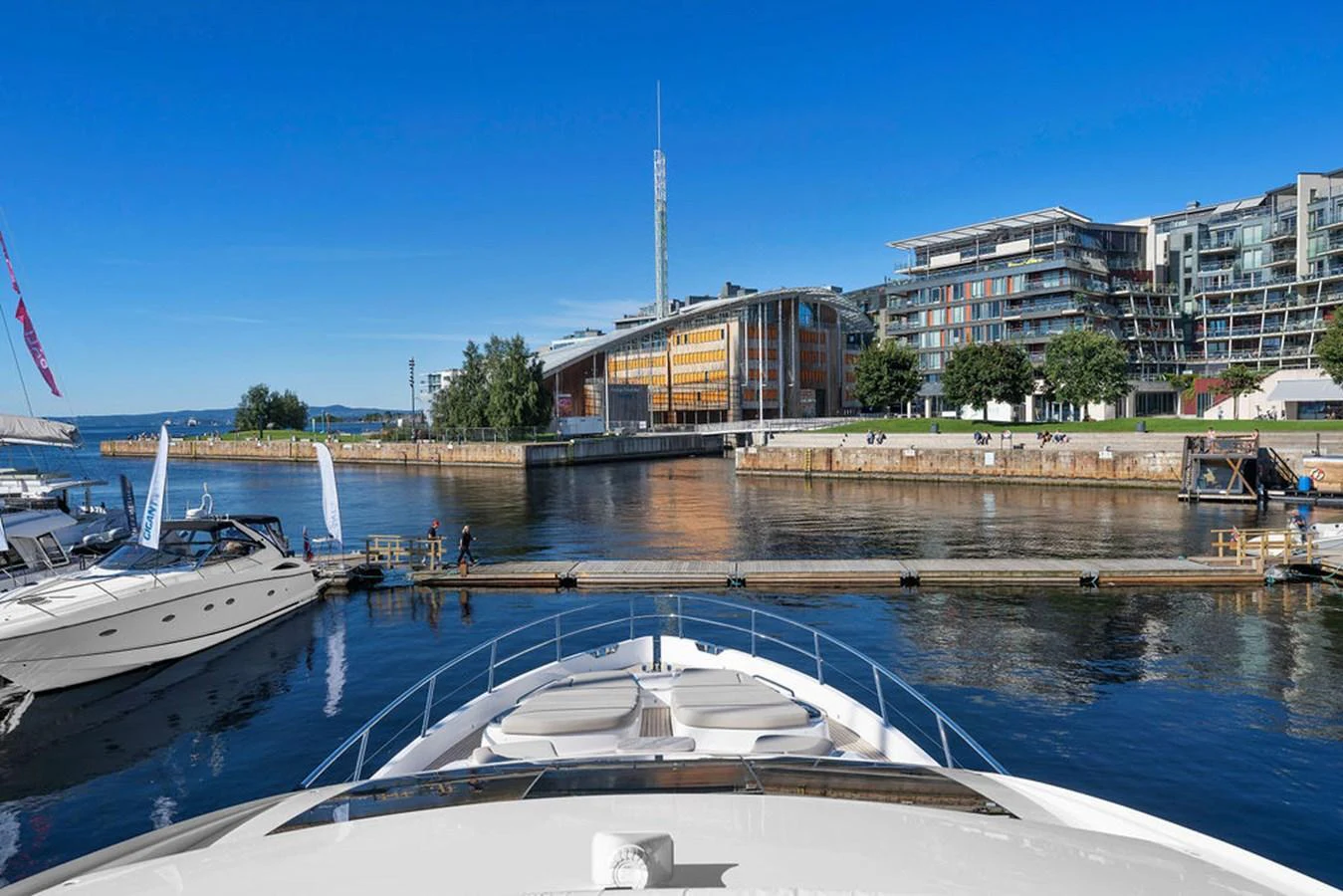 The yacht is docked in a picturesque marina with modern buildings in the background. aboard PRINCESS S72 Yacht for Sale