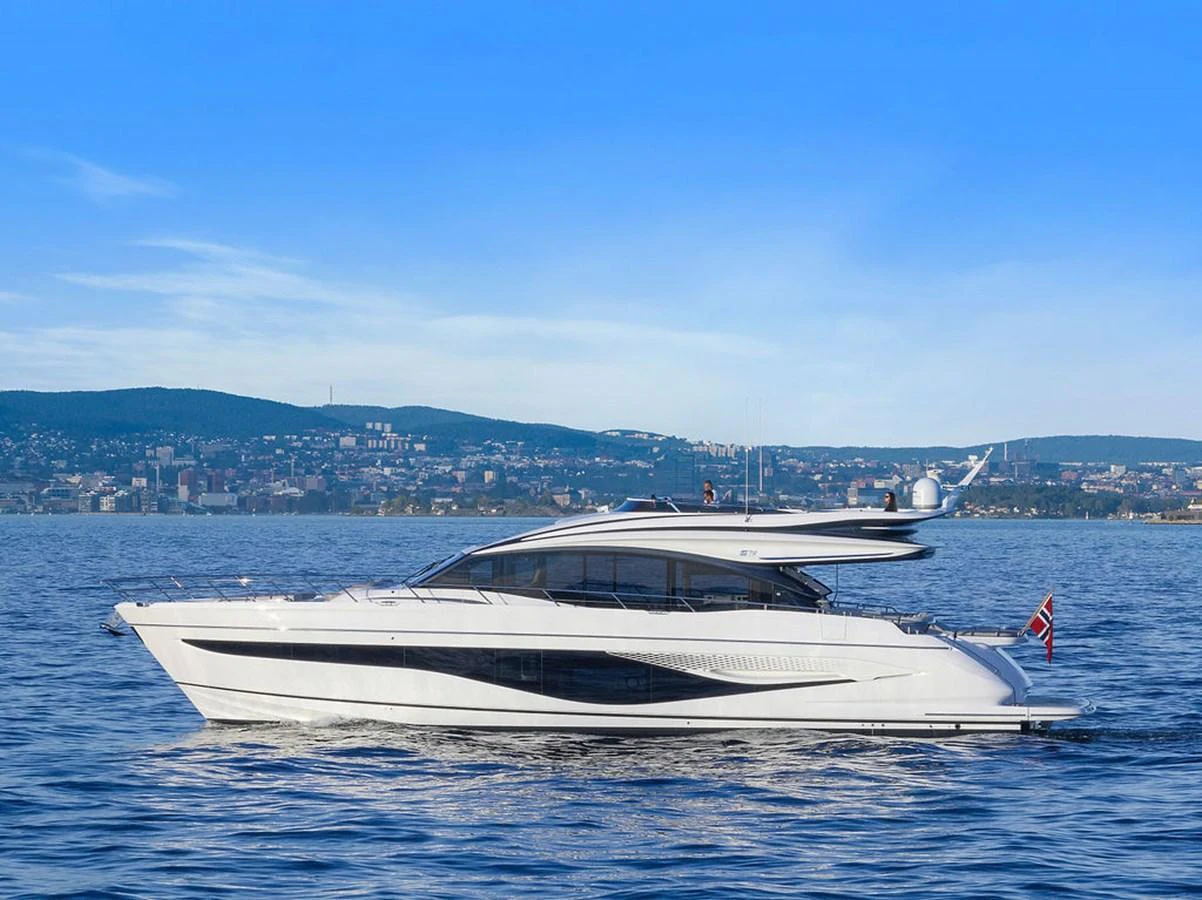 A sleek and modern yacht cruising on calm waters with a scenic coastal backdrop. aboard PRINCESS S72 Yacht for Sale