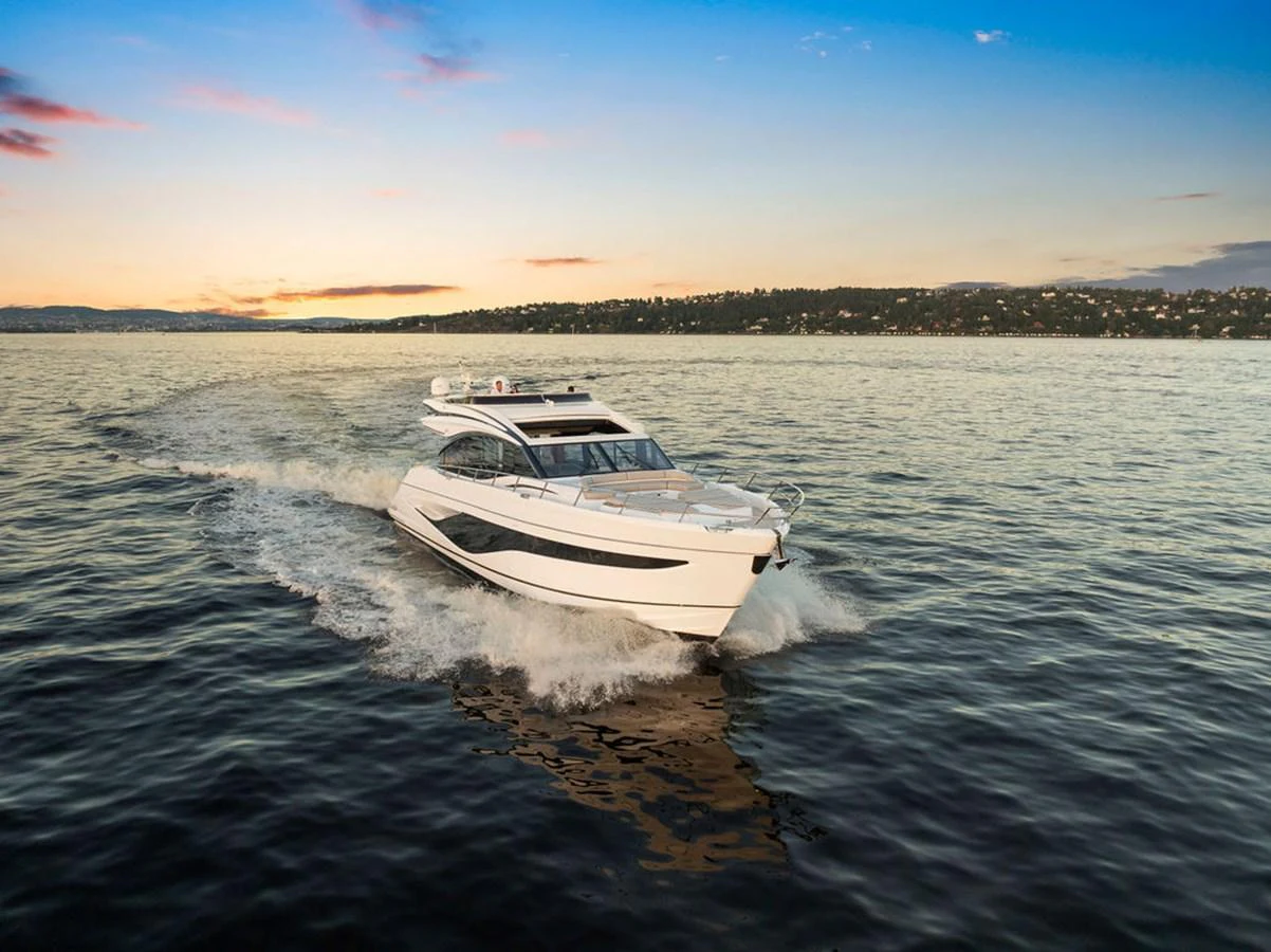 A sleek and modern yacht cruises swiftly across calm waters at sunset. aboard PRINCESS S72 Yacht for Sale