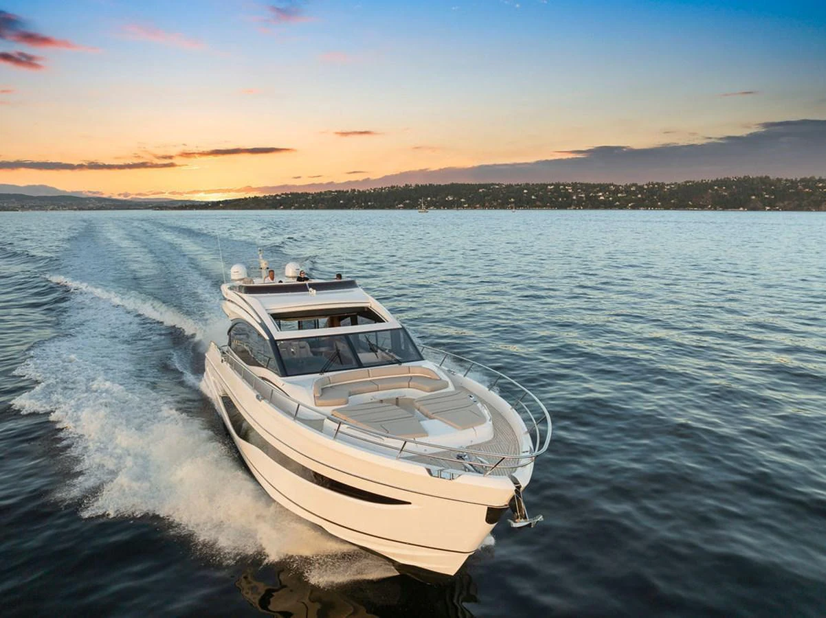 A sleek yacht cruises through calm waters at sunset, showcasing its elegant design. aboard PRINCESS S72 Yacht for Sale