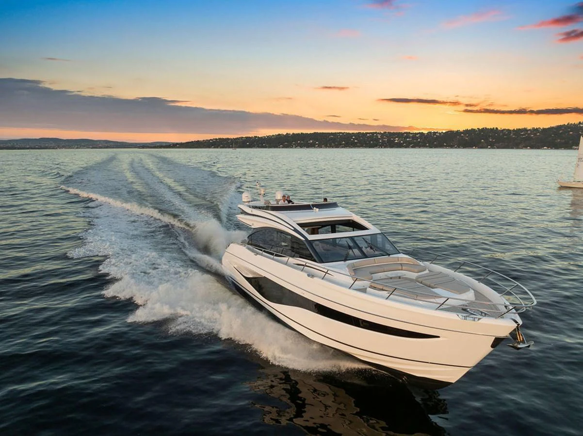 A sleek and modern yacht cruises through calm waters at sunset. aboard PRINCESS S72 Yacht for Sale