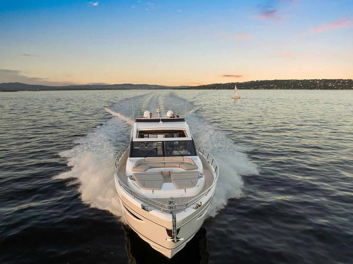 A sleek yacht cruises through calm waters at sunset, leaving a trail behind. aboard PRINCESS S72 Yacht for Sale
