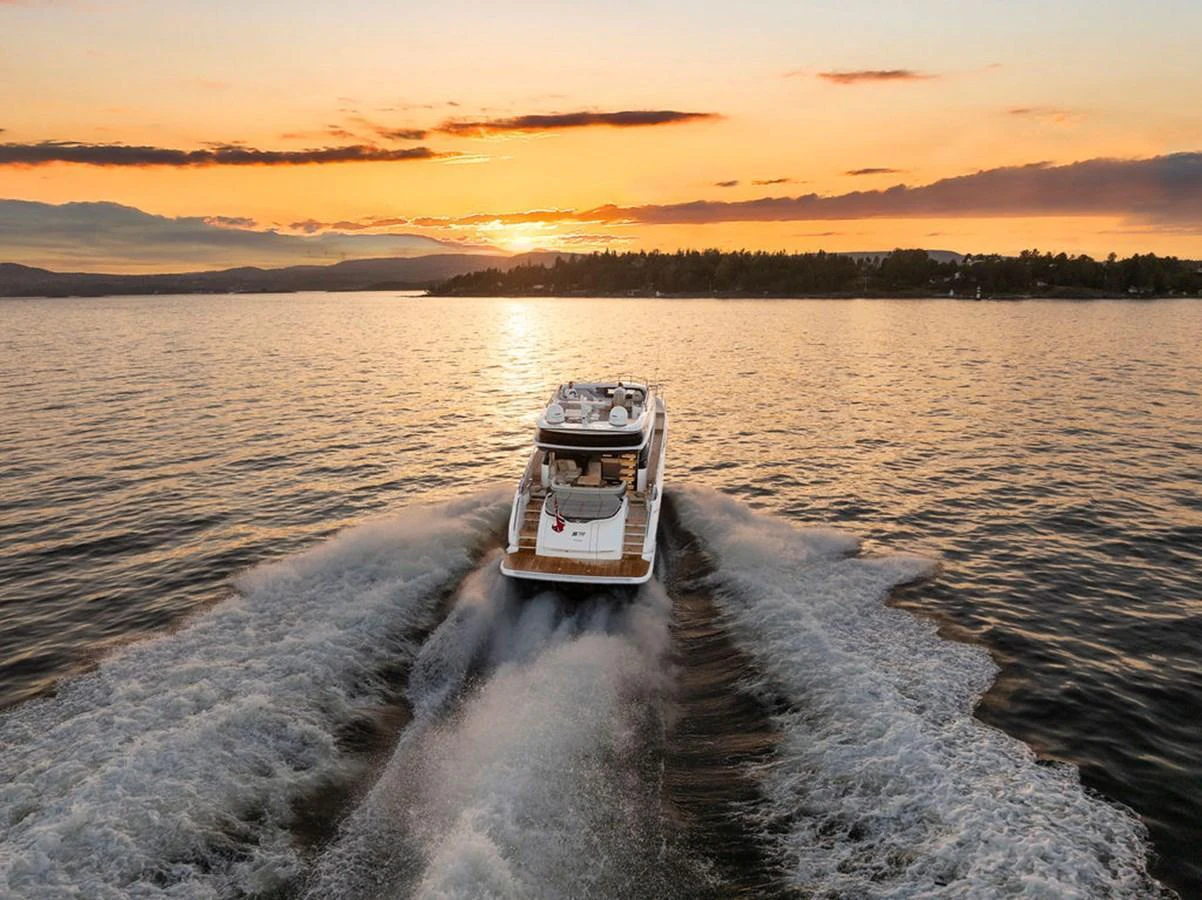A luxurious yacht cruises through the water at sunset, leaving a beautiful wake behind. aboard PRINCESS S72 Yacht for Sale