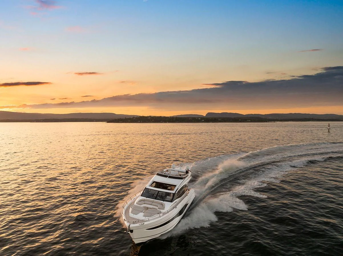 A sleek yacht cruises through calm waters at sunset, showcasing its elegant design and powerful performance. aboard PRINCESS S72 Yacht for Sale