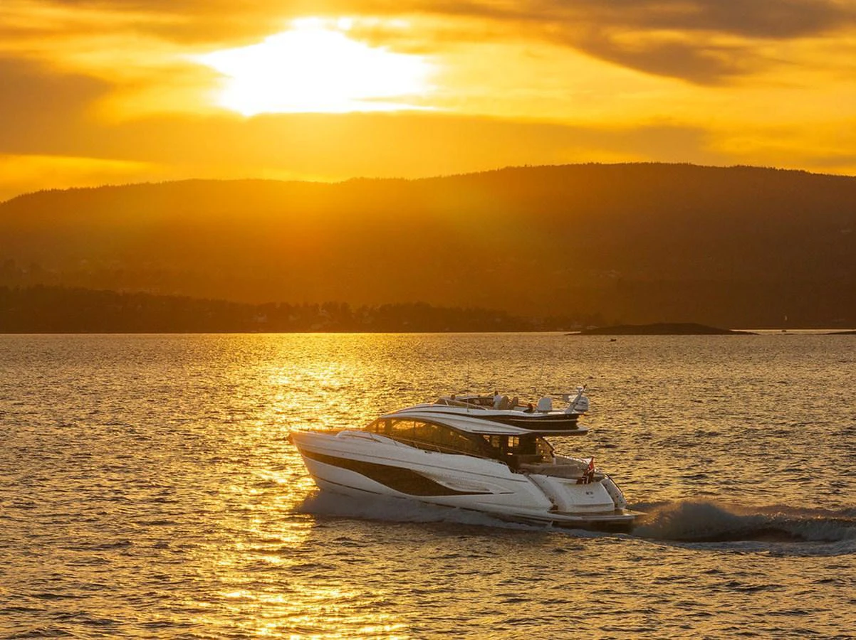 A sleek yacht cruises through the water at sunset, creating a serene and picturesque scene. aboard PRINCESS S72 Yacht for Sale