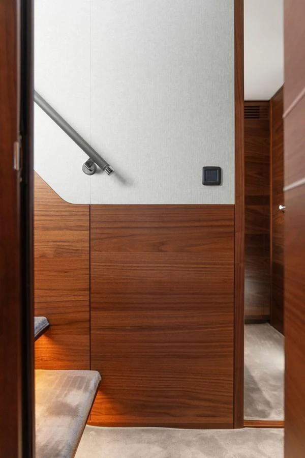 A sleek interior stairway with wooden paneling and modern design elements. aboard PRINCESS S72 Yacht for Sale