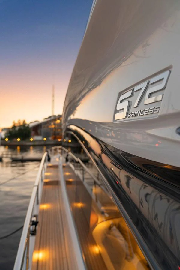A close-up view of the yacht's sleek exterior with elegant lighting and branding. aboard PRINCESS S72 Yacht for Sale