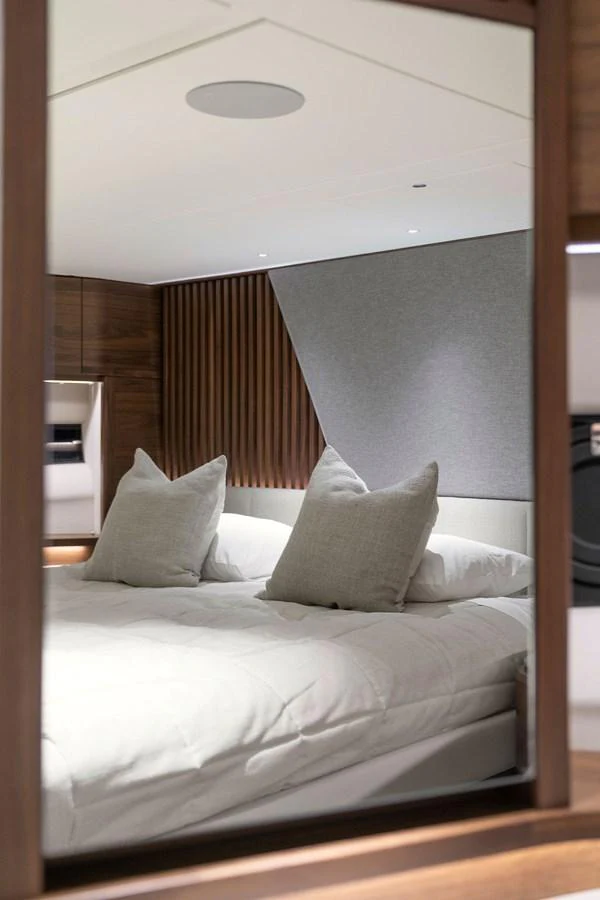 A luxurious stateroom featuring a plush bed with elegant pillows and modern wooden accents. aboard PRINCESS S72 Yacht for Sale