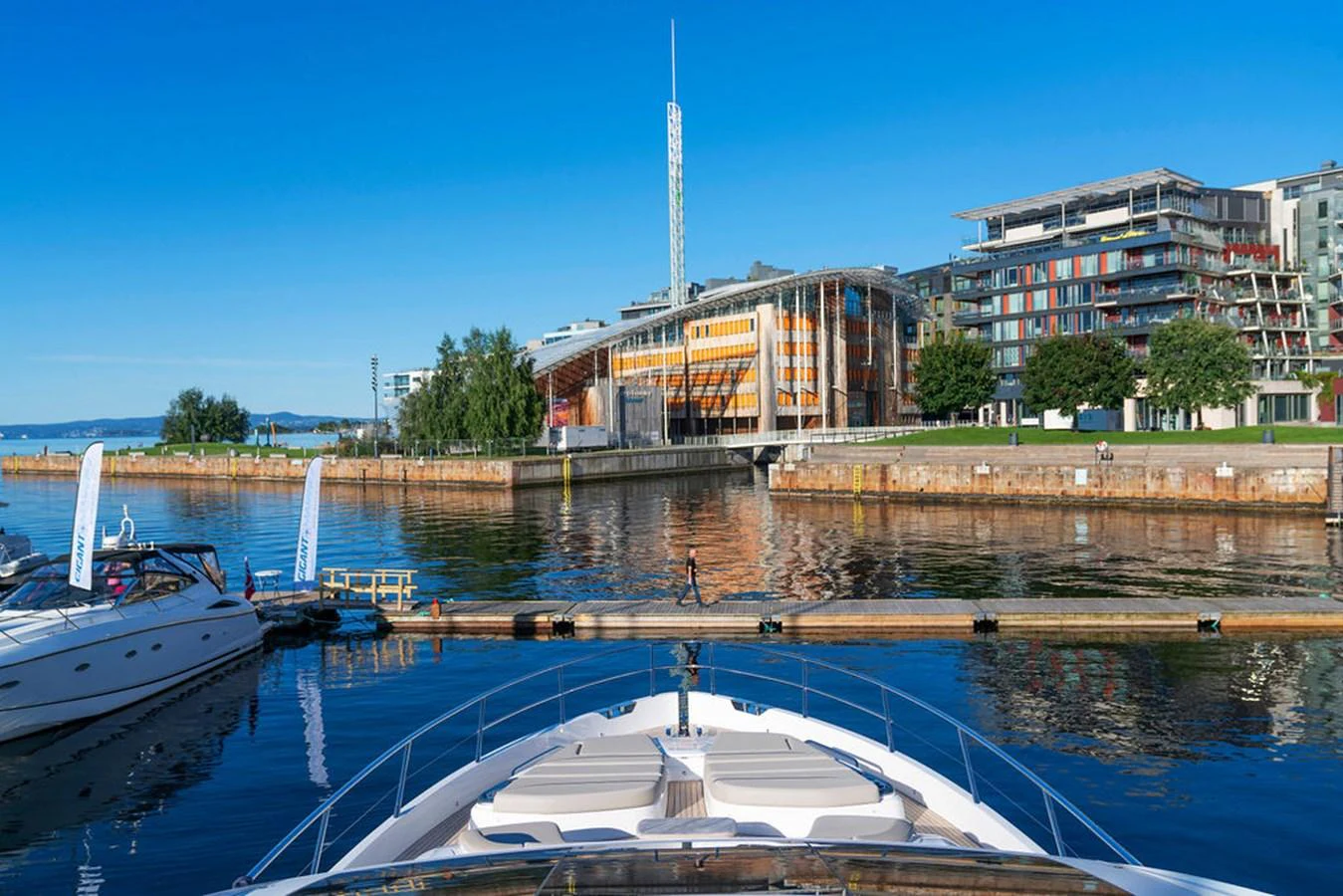 The yacht is docked in a serene marina with modern buildings in the background. aboard PRINCESS S72 Yacht for Sale