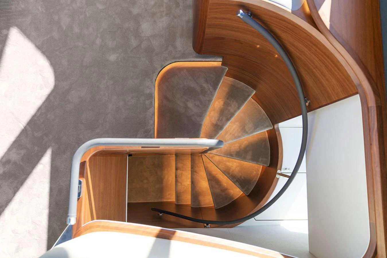 A beautifully designed wooden spiral staircase with elegant railings. aboard PRINCESS S72 Yacht for Sale