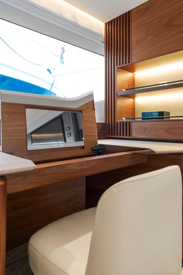 The yacht's interior features a stylish workspace with a wooden desk and a comfortable chair. aboard PRINCESS S72 Yacht for Sale