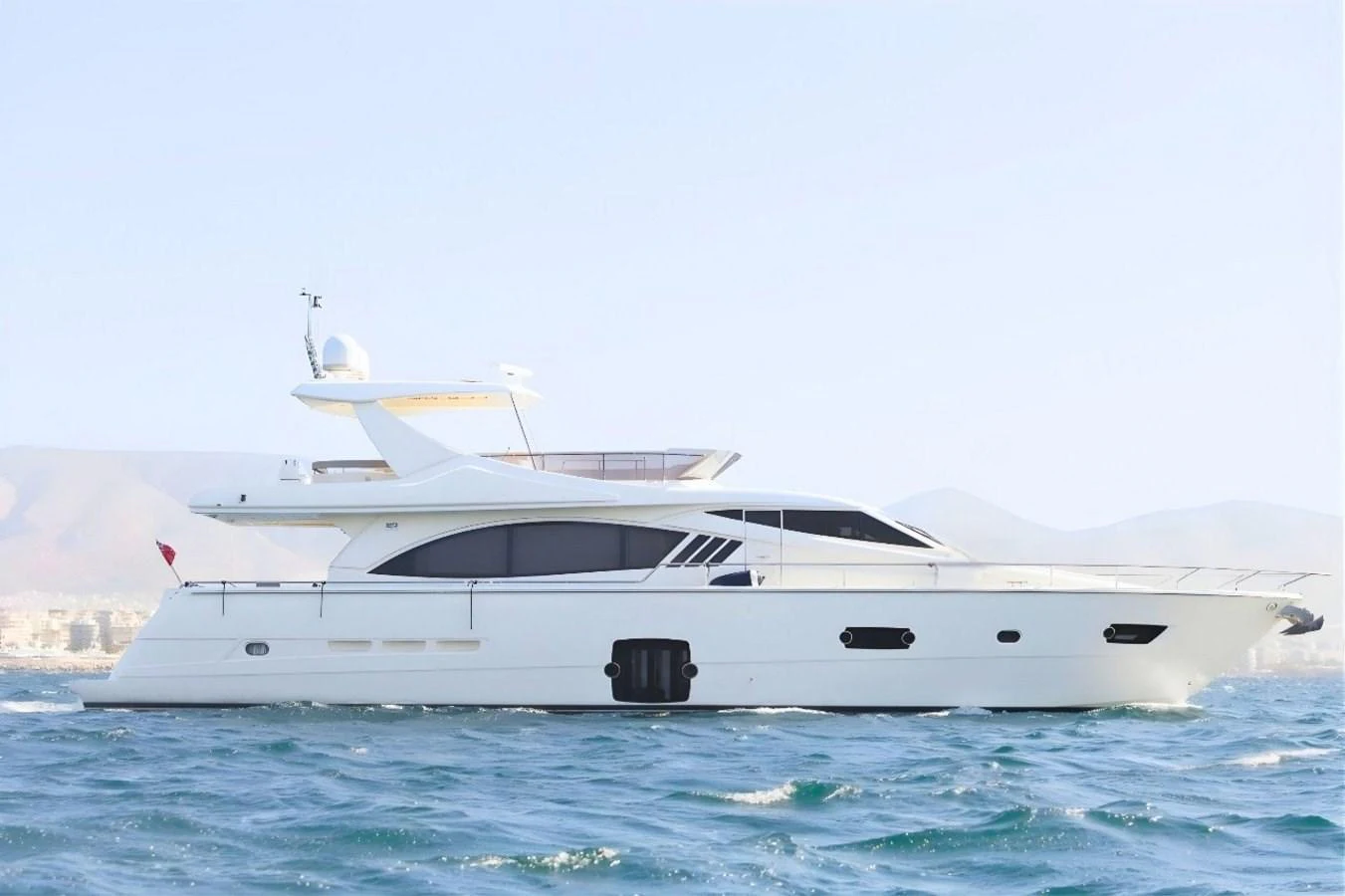 A sleek, modern yacht cruising on calm waters with a clear sky backdrop. aboard M/Y EM- II Yacht for Sale