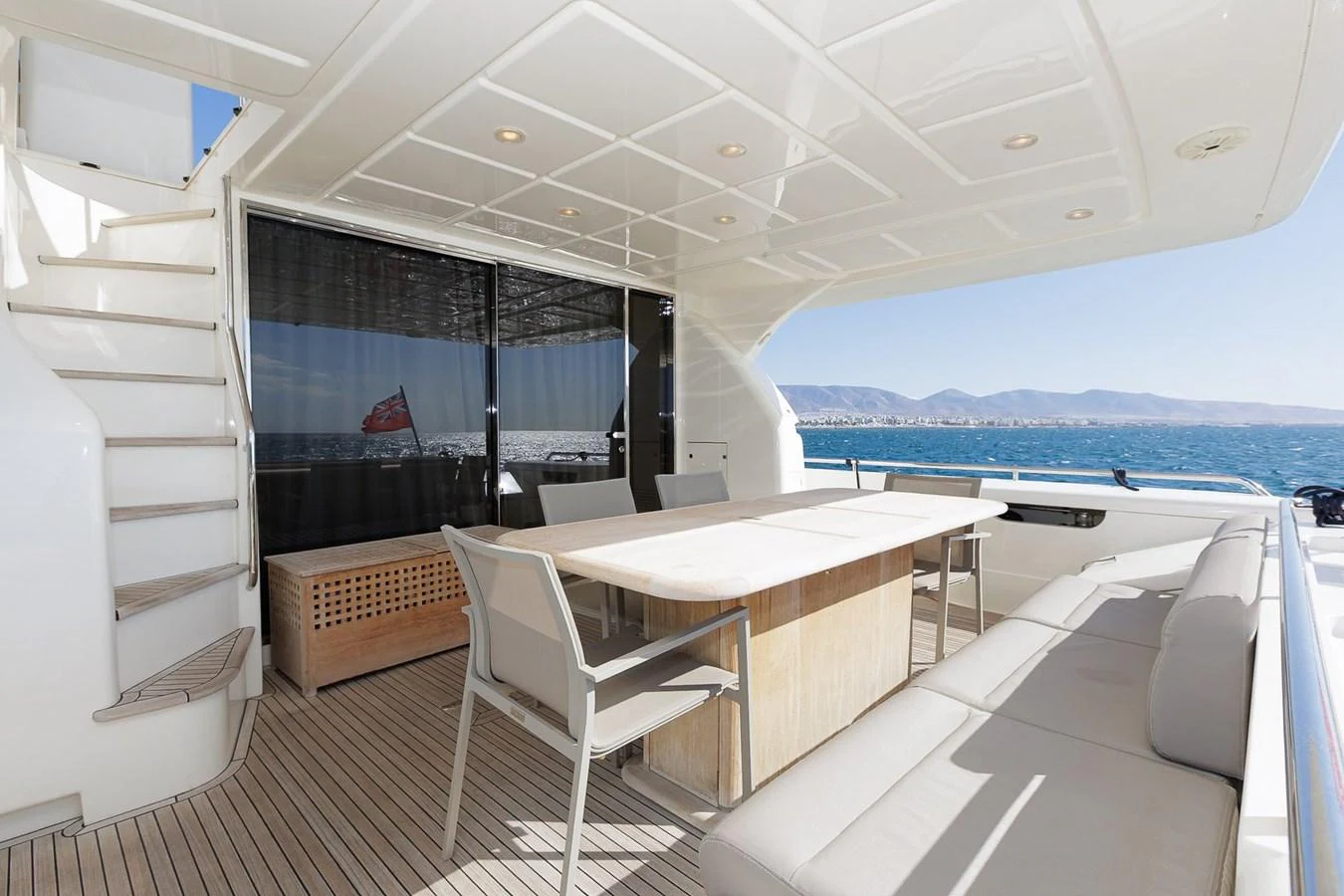 The aft deck features a spacious seating area with a dining table, perfect for alfresco meals with a view of the sea. aboard M/Y EM- II Yacht for Sale