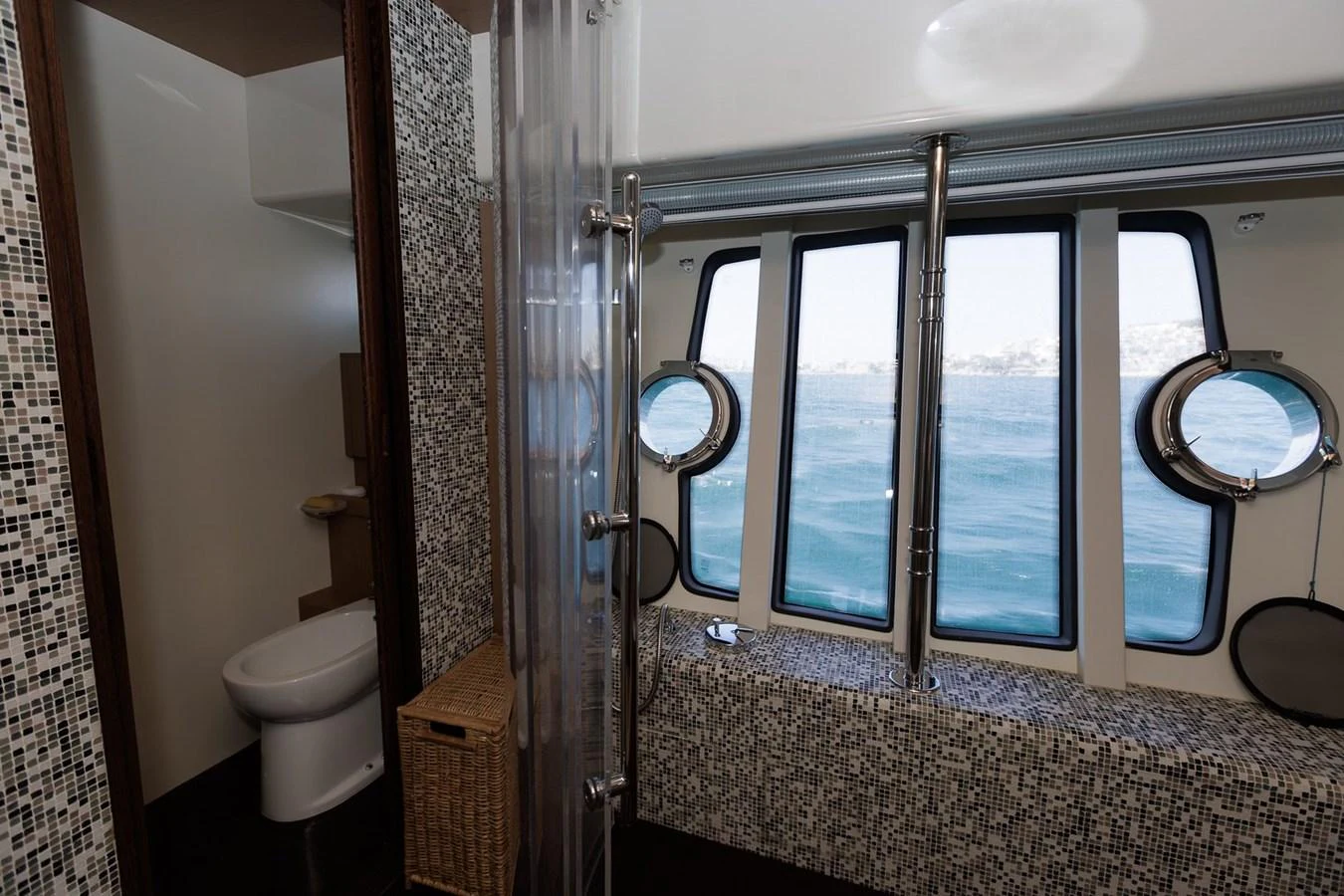 A stylish yacht bathroom with a view of the sea through large windows. aboard M/Y EM- II Yacht for Sale