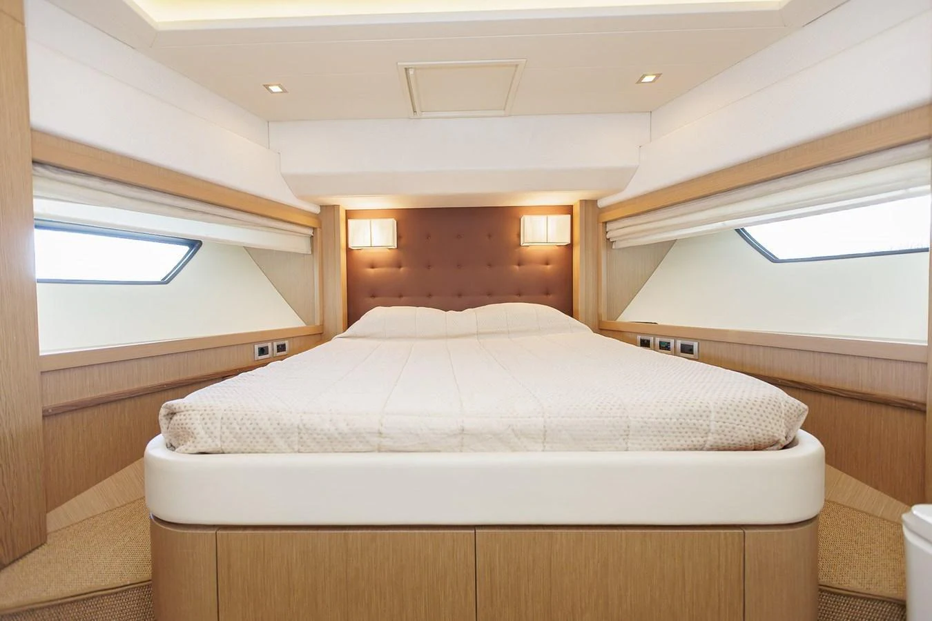The master stateroom features a spacious bed with elegant lighting and ample natural light from the windows. aboard M/Y EM- II Yacht for Sale
