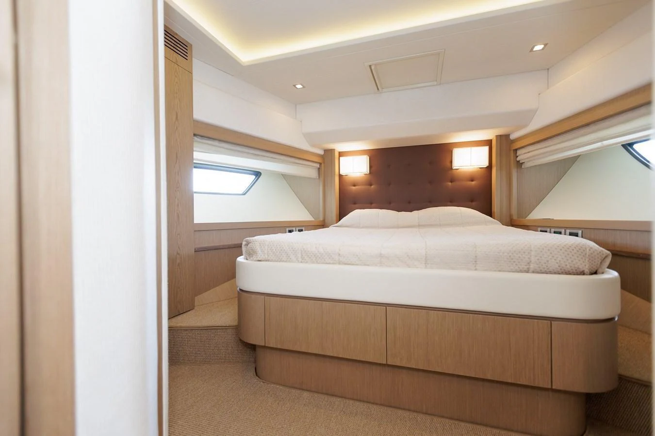 The stateroom features a plush bed with elegant wood paneling and ample natural light. aboard M/Y EM- II Yacht for Sale