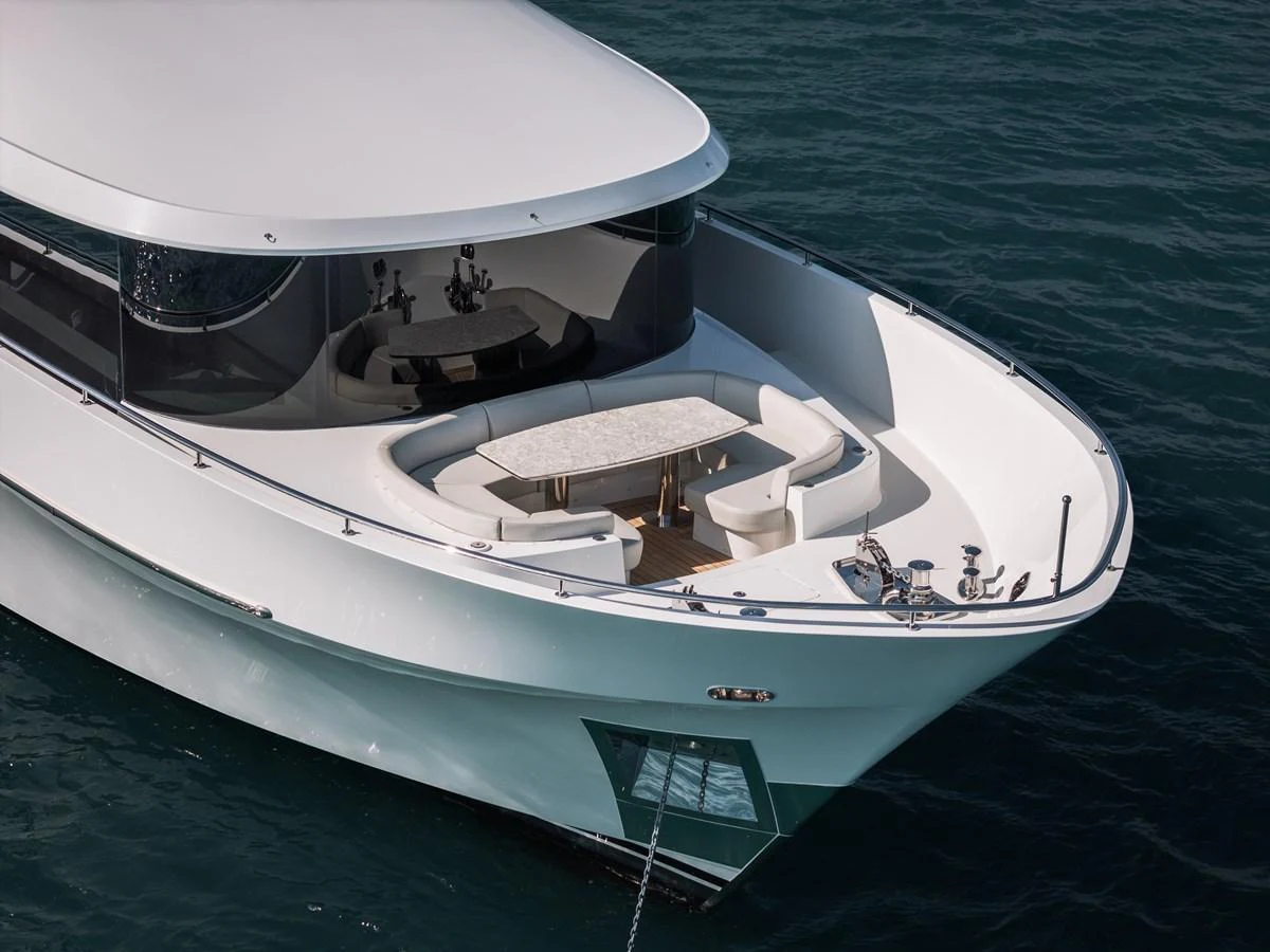 The yacht features a sleek bow seating area with a modern table and comfortable seating, perfect for enjoying the ocean views. aboard LA LA LA Yacht for Sale