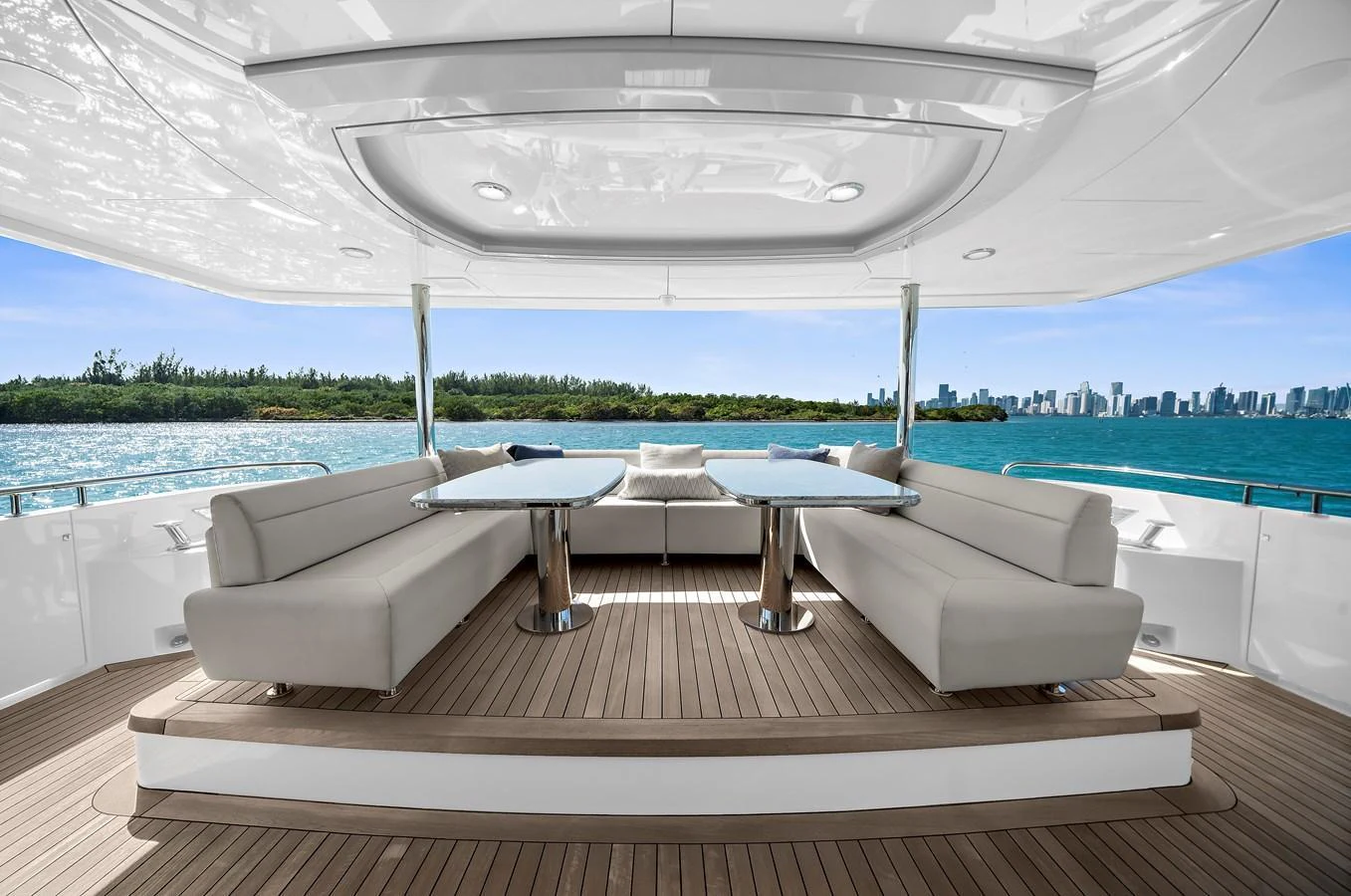 The aft deck features a spacious seating area with elegant tables, offering stunning views of the surrounding waters and skyline. aboard LA LA LA Yacht for Sale