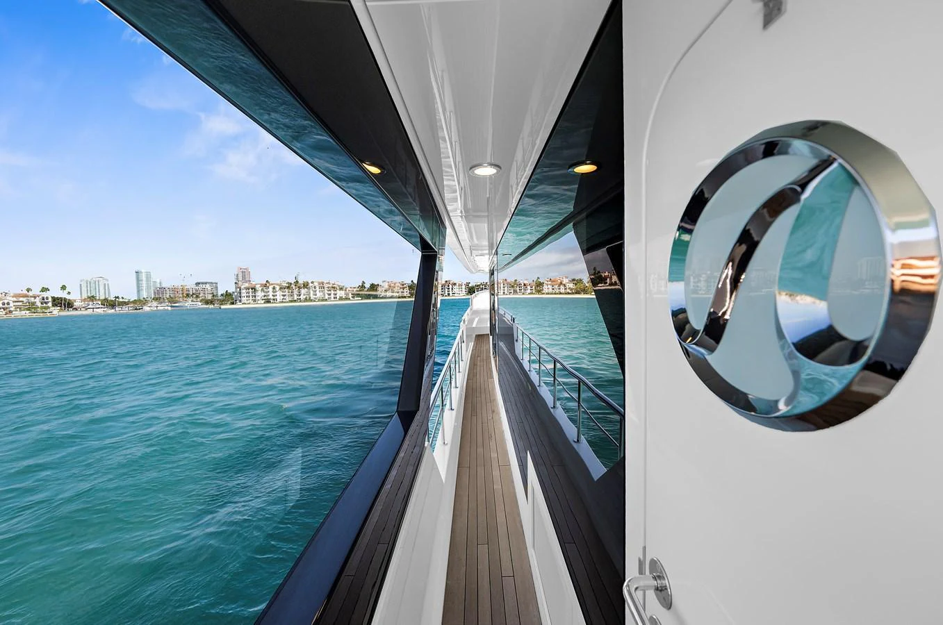 The sleek side deck of the yacht offers a stunning view of the surrounding waters and cityscape. aboard LA LA LA Yacht for Sale
