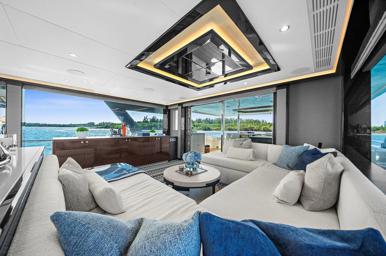 The spacious salon features plush seating and expansive windows offering stunning ocean views. aboard LA LA LA Yacht for Sale