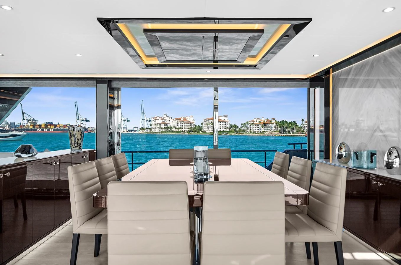 The yacht's dining area offers a luxurious setting with a stunning view of the water. aboard LA LA LA Yacht for Sale