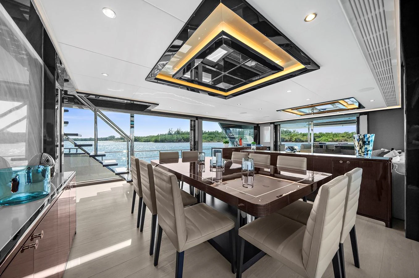 The yacht's dining area features a modern and elegant design with large windows offering stunning views. aboard LA LA LA Yacht for Sale