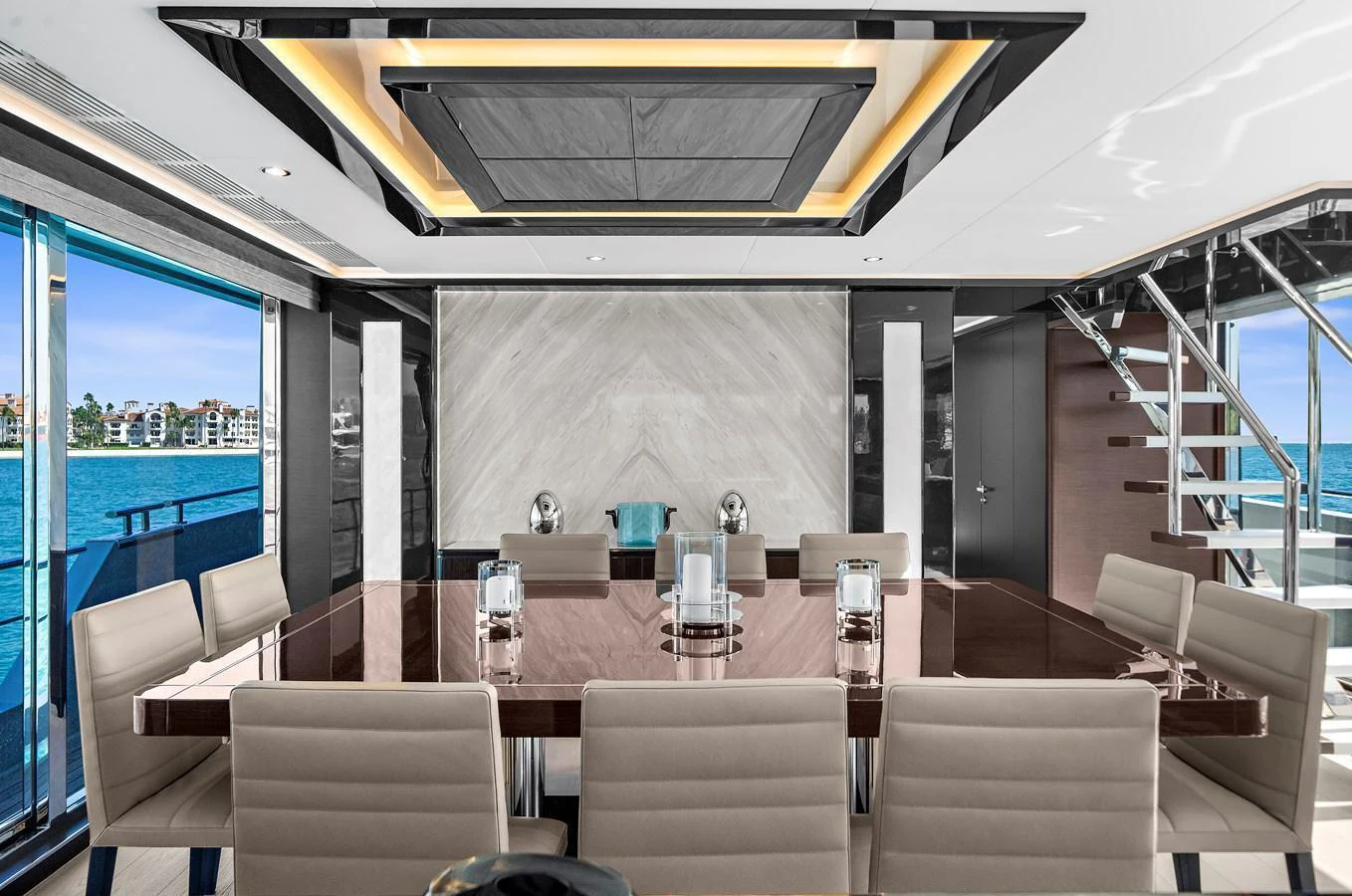 The yacht's dining area features a sleek, modern design with a large table and comfortable seating, offering stunning views through expansive windows. aboard LA LA LA Yacht for Sale