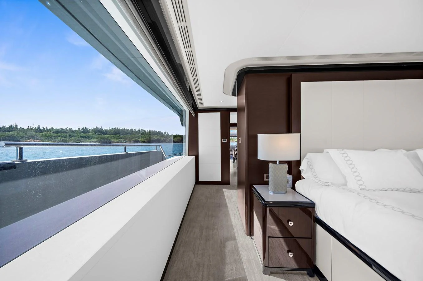 A luxurious stateroom with a large window offering a stunning view of the water. aboard LA LA LA Yacht for Sale