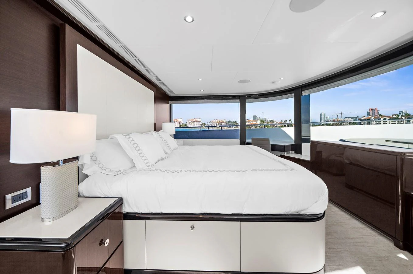 The master stateroom features a luxurious bed with panoramic views through large windows. aboard LA LA LA Yacht for Sale