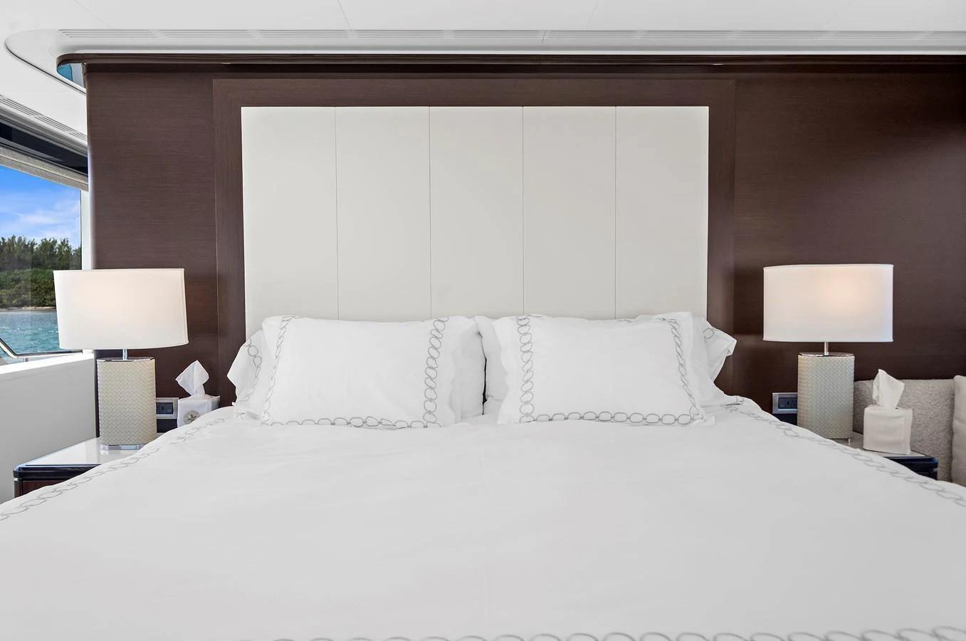 The master stateroom features a luxurious bed with elegant bedding and modern bedside lamps. aboard LA LA LA Yacht for Sale