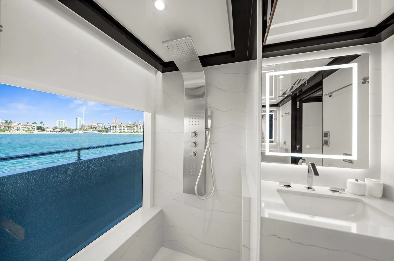 A luxurious yacht bathroom with a modern shower and a large window offering a stunning ocean view. aboard LA LA LA Yacht for Sale