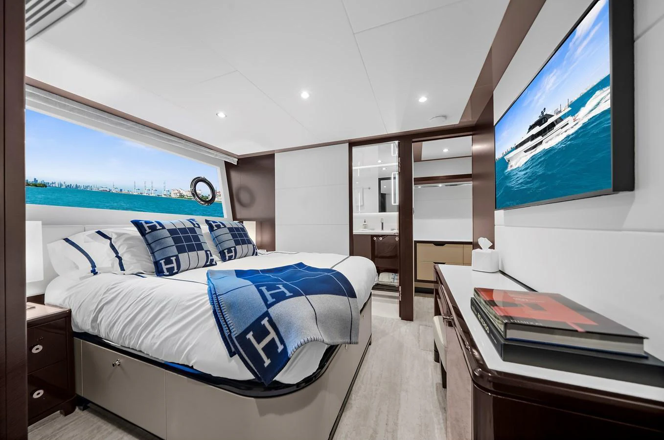 A luxurious stateroom featuring a large bed, modern decor, and a scenic window view. aboard LA LA LA Yacht for Sale