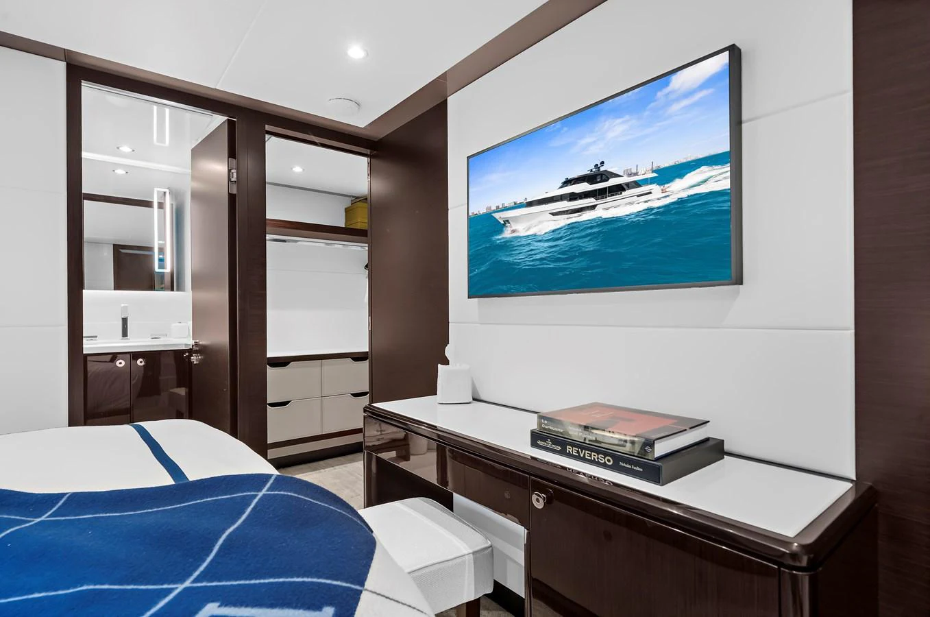 A luxurious stateroom featuring a modern design with a flat-screen TV and elegant decor. aboard LA LA LA Yacht for Sale