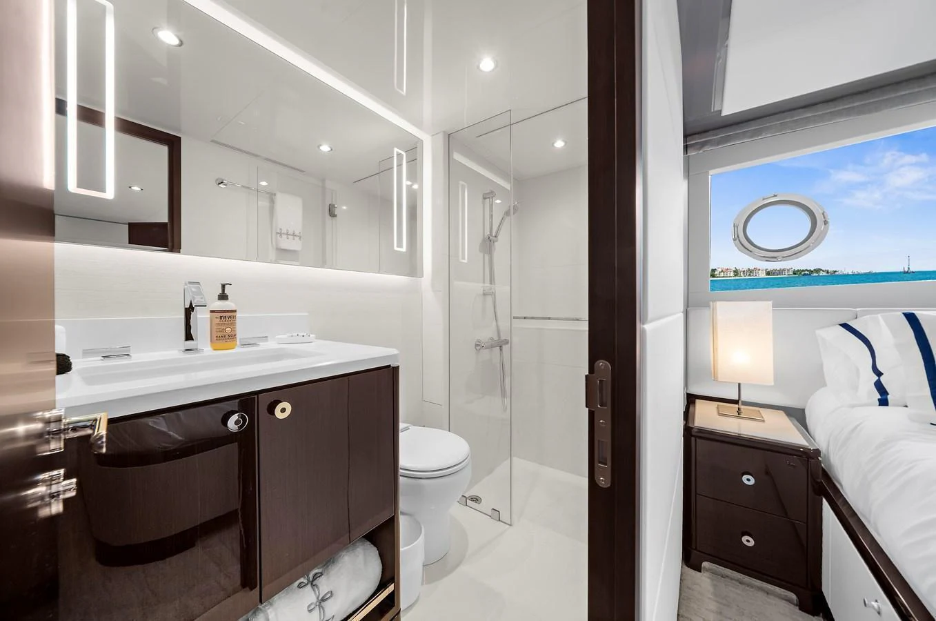 A pristine yacht bathroom with modern fixtures and an adjacent cozy bedroom. aboard LA LA LA Yacht for Sale