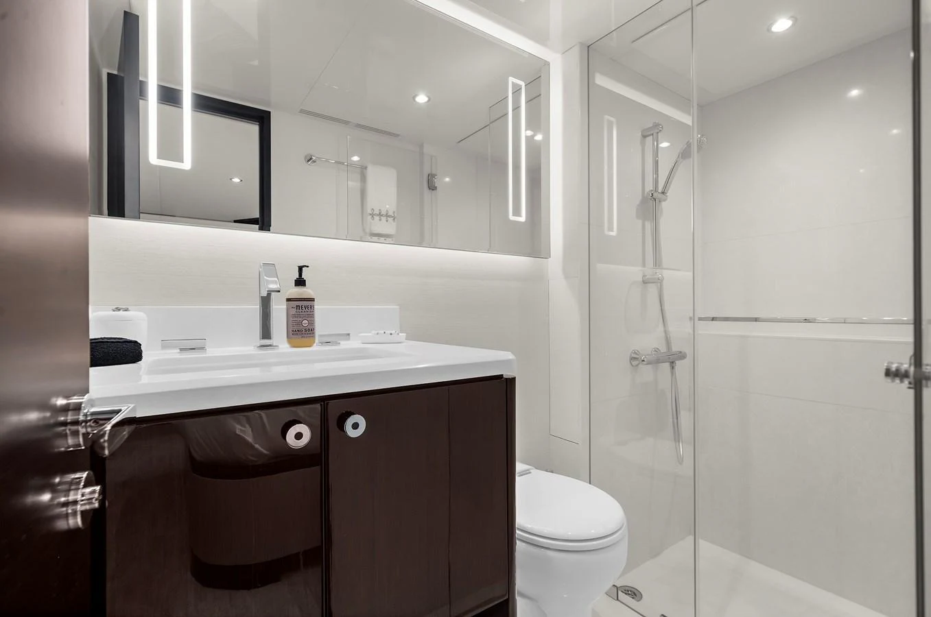 A sleek and modern bathroom with a glass-enclosed shower and elegant fixtures. aboard LA LA LA Yacht for Sale