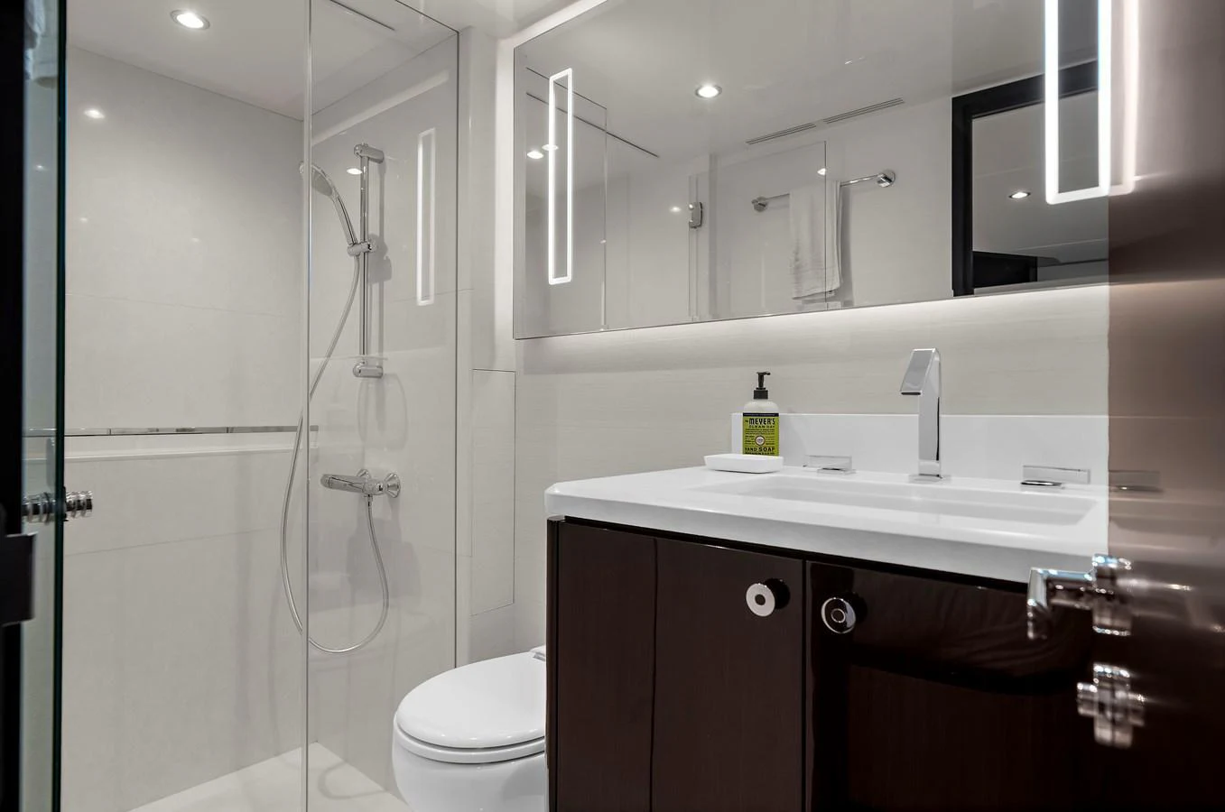 A sleek and modern yacht bathroom with a glass-enclosed shower and contemporary fixtures. aboard LA LA LA Yacht for Sale