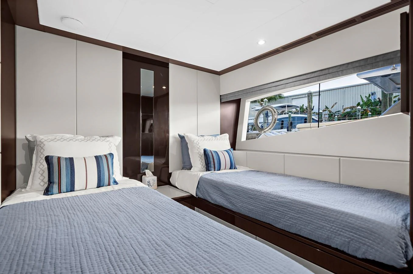 The twin stateroom offers a cozy and modern retreat with two single beds and a large window providing ample natural light. aboard LA LA LA Yacht for Sale