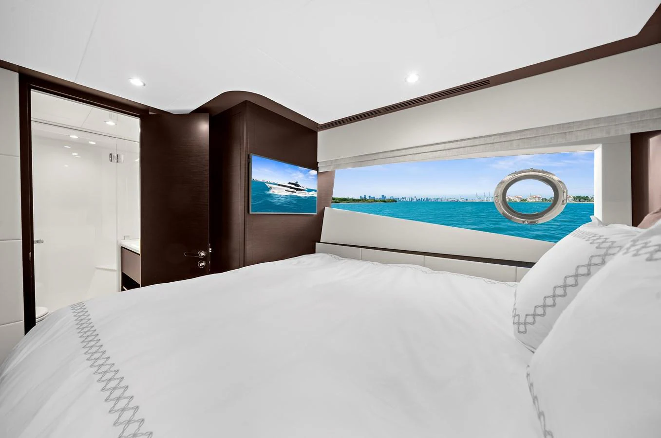 A luxurious stateroom featuring a large bed and a scenic ocean view through the window. aboard LA LA LA Yacht for Sale