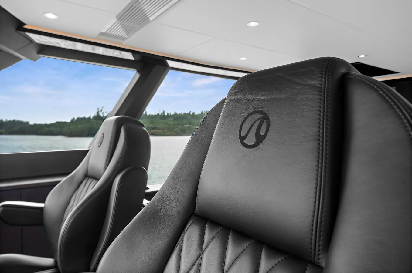 The helm features luxurious leather seating with a view of the serene waters outside. aboard LA LA LA Yacht for Sale