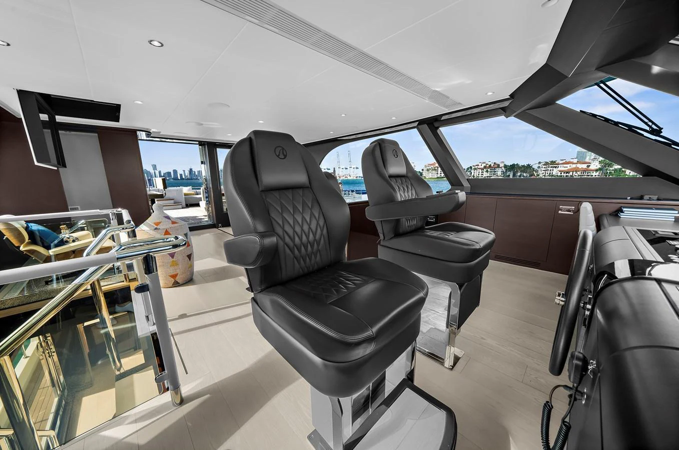 The helm station features luxurious leather chairs with a panoramic view of the surroundings. aboard LA LA LA Yacht for Sale