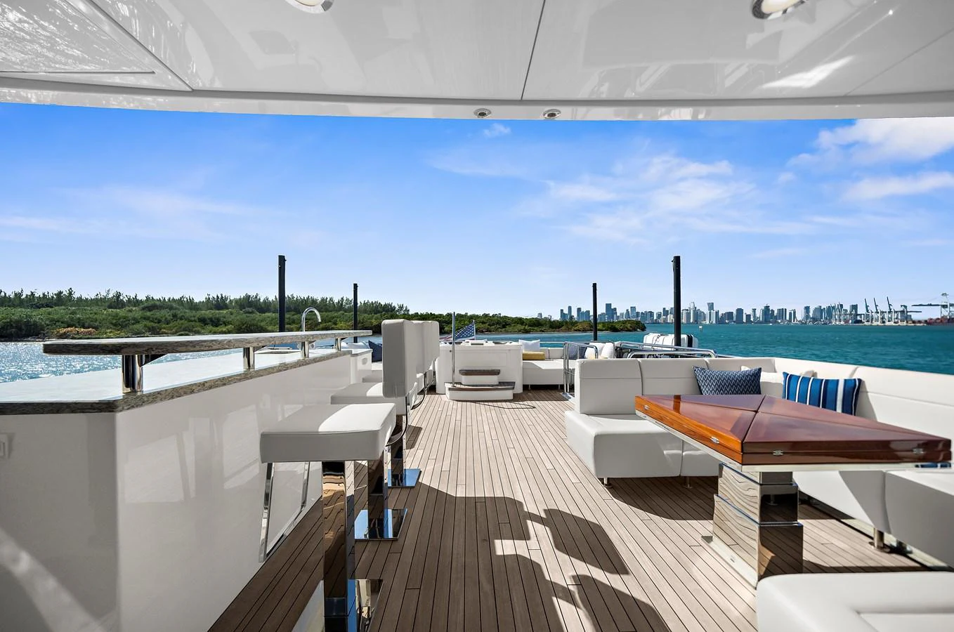 The aft deck offers a spacious and luxurious outdoor seating area with stunning views of the water and city skyline. aboard LA LA LA Yacht for Sale