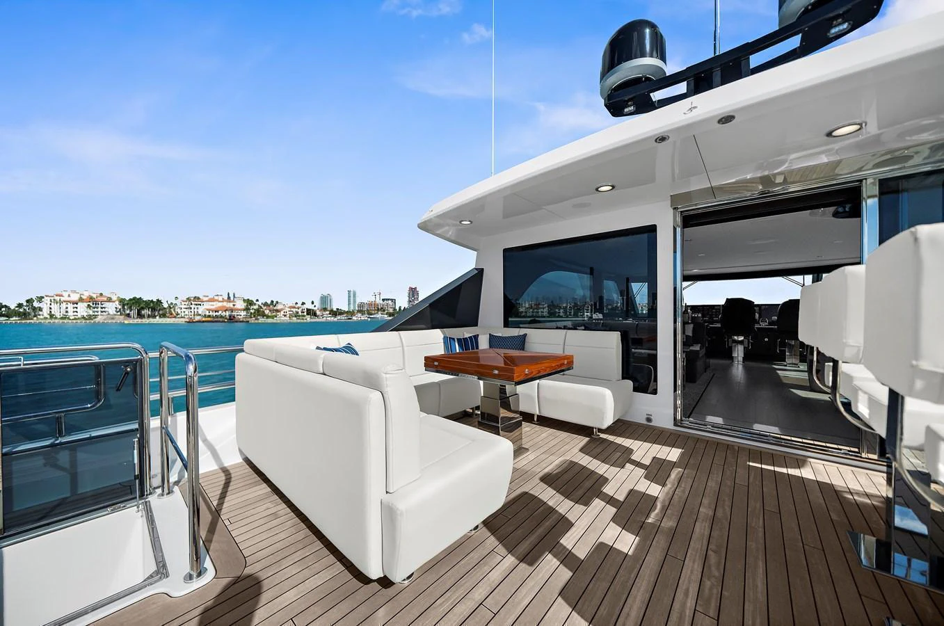 The yacht's aft deck features a spacious seating area with a wooden table, perfect for outdoor relaxation and dining. aboard LA LA LA Yacht for Sale