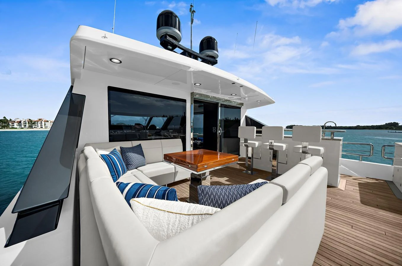 The aft deck features a comfortable seating area with a wooden table, perfect for outdoor relaxation and dining. aboard LA LA LA Yacht for Sale