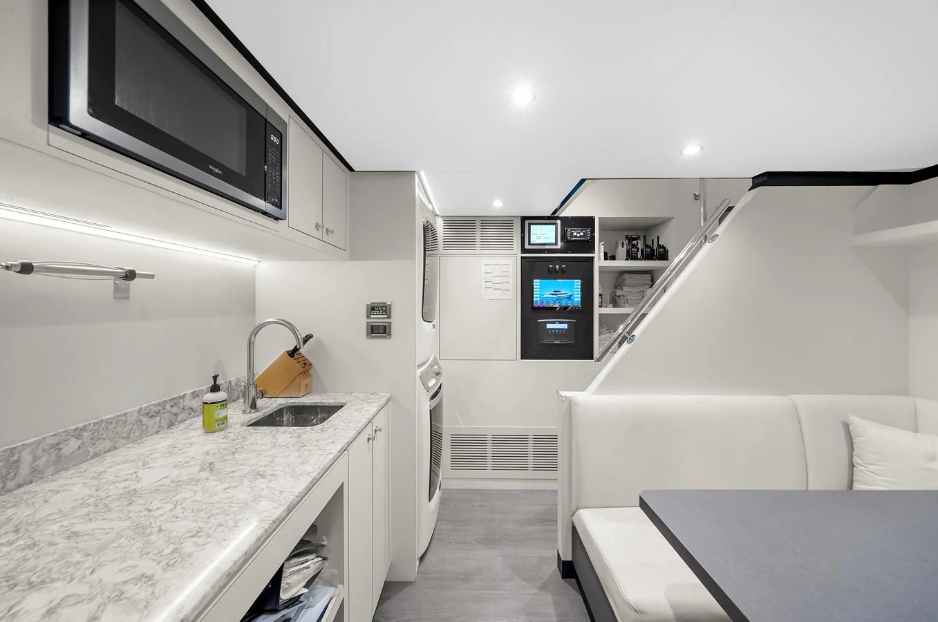 This modern galley features sleek appliances and a cozy dining area. aboard LA LA LA Yacht for Sale