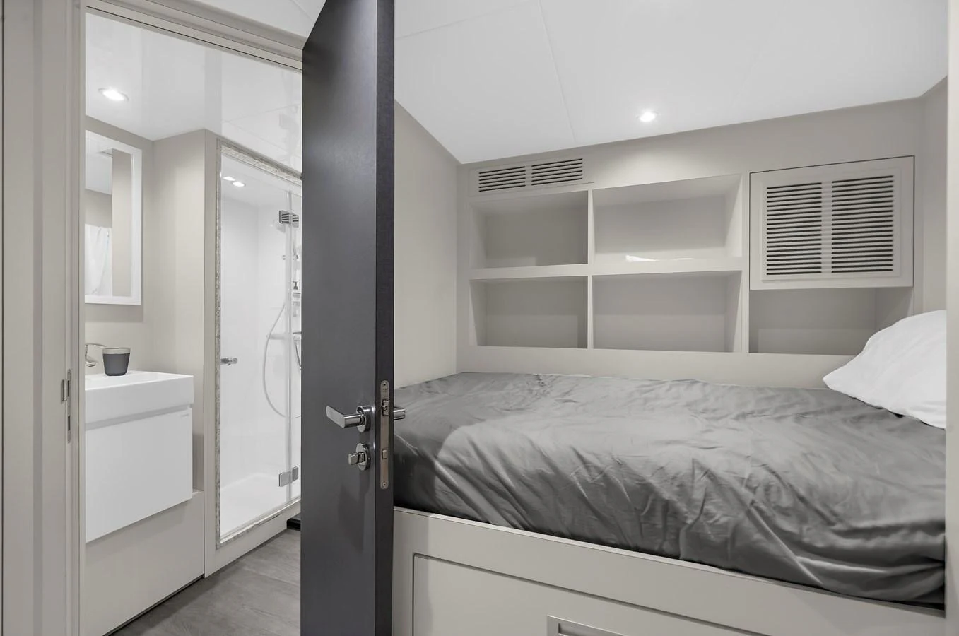 A cozy guest cabin with an ensuite bathroom, featuring modern design and ample storage. aboard LA LA LA Yacht for Sale