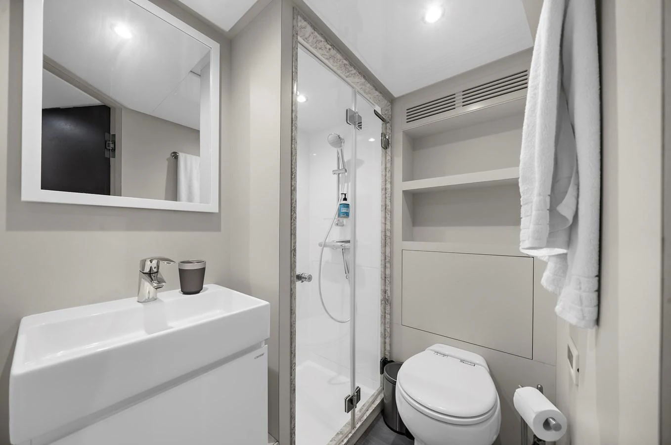 The yacht's bathroom features a modern design with a glass-enclosed shower and sleek fixtures. aboard LA LA LA Yacht for Sale