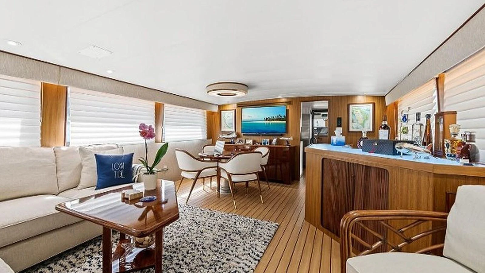 The salon features elegant furnishings with a blend of wood and neutral tones, creating a warm and inviting atmosphere. aboard TOP GUN Yacht for Sale