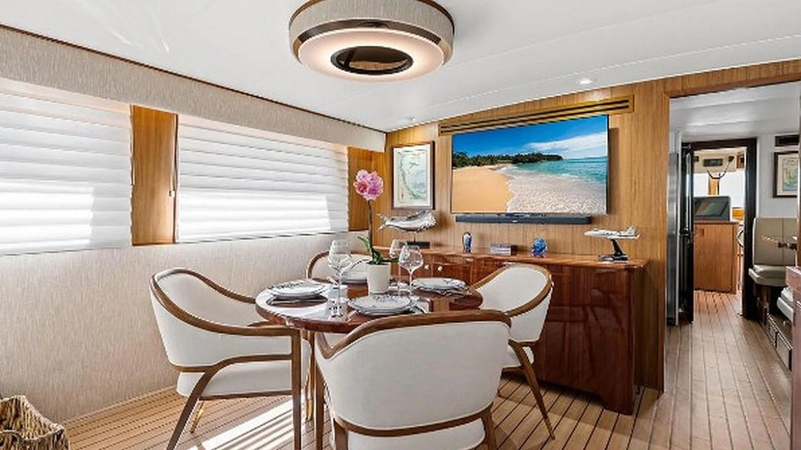 The yacht's dining area features elegant seating and a large flat-screen TV, creating a luxurious and comfortable atmosphere. aboard TOP GUN Yacht for Sale