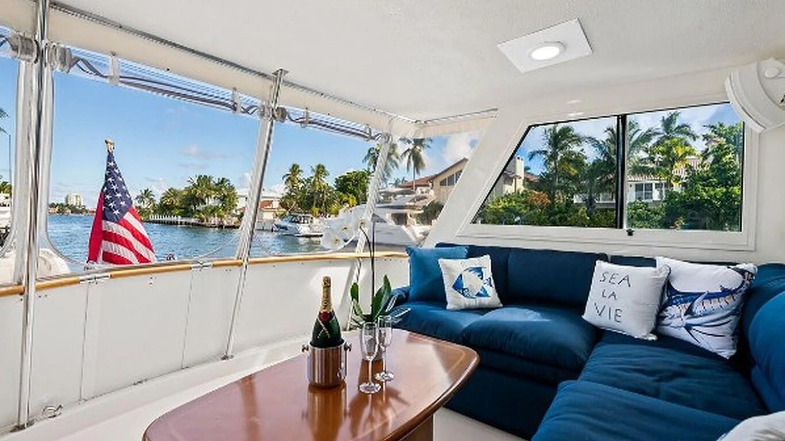 The salon offers a cozy seating area with a stunning view of the water and surrounding landscape. aboard TOP GUN Yacht for Sale