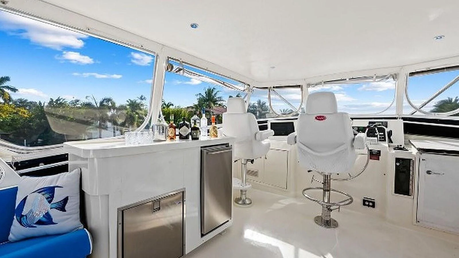 The helm area features modern seating and a well-equipped bar with a scenic view. aboard TOP GUN Yacht for Sale